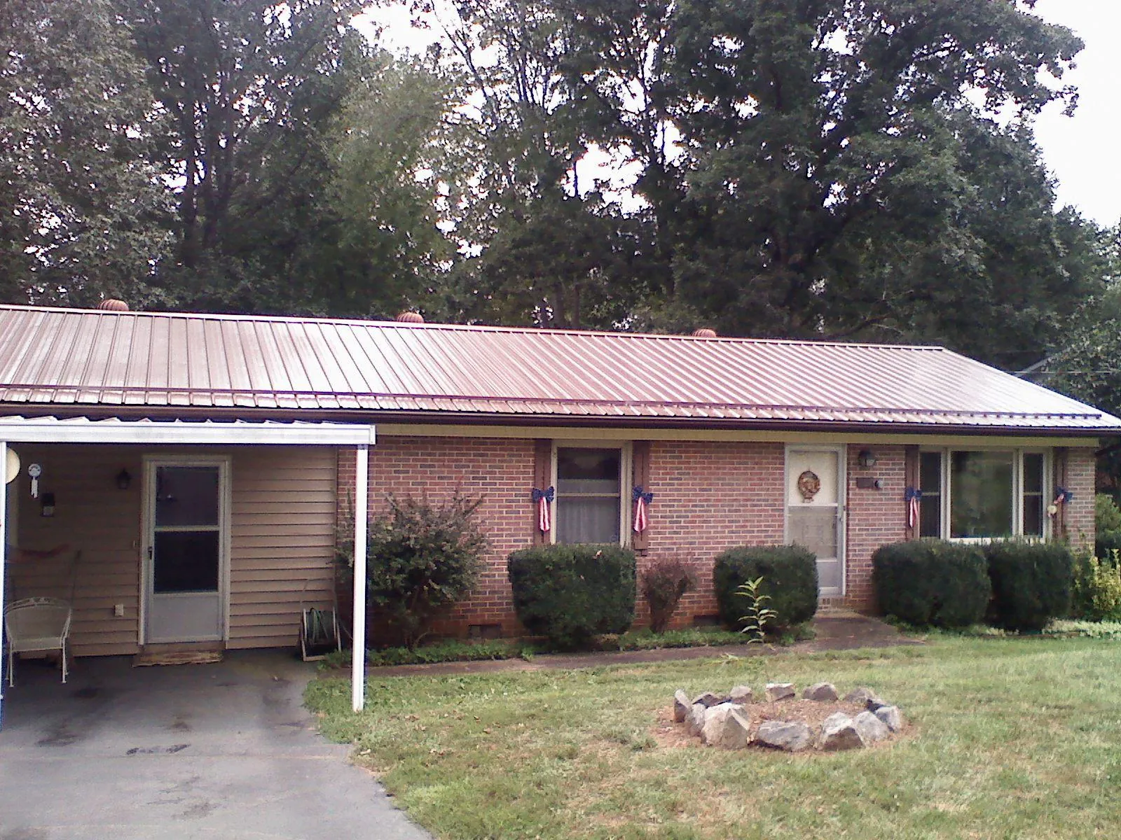 Bronze metal roof and carport on a brick ranch home — Roof Repair work by our crew in Drayton